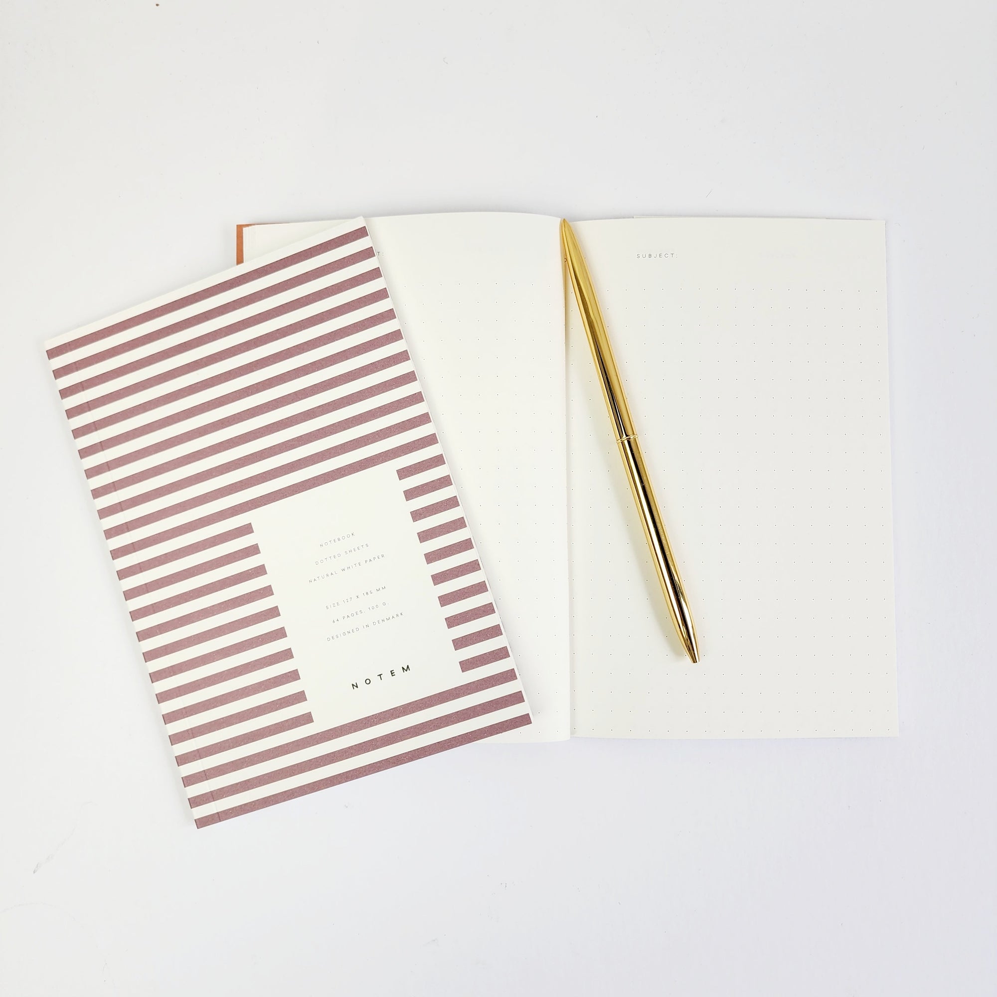 Image of opened and closed bordeaux stripped notebook with gold pen.  