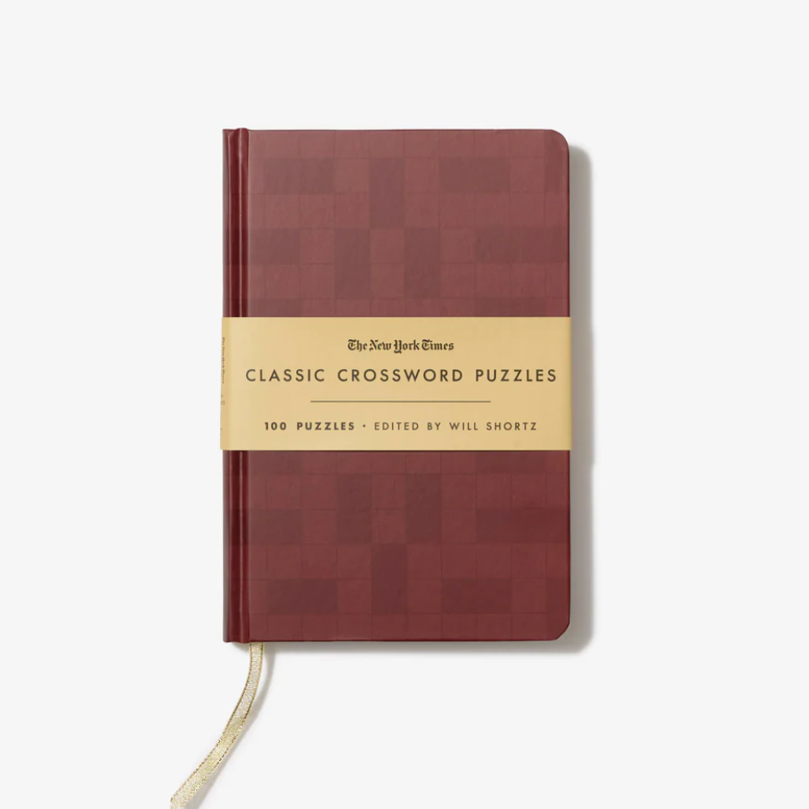 Brown notebook with a gold band featuring 'The New York Times Classic Crossword Puzzles' on a white background