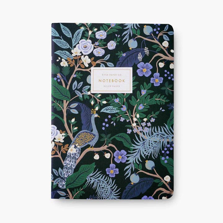 Peacock notebook one, black with peacock illustration with white label and gold lettering on white background.