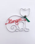 Personalized cat ornament, featuring an image of a cat crafted from silver  aluminum wire that forms the outline of a cat's body and head, complete with a green bow and a silver bell. In the center is personalized with the name Ginger in red aluminum wire.