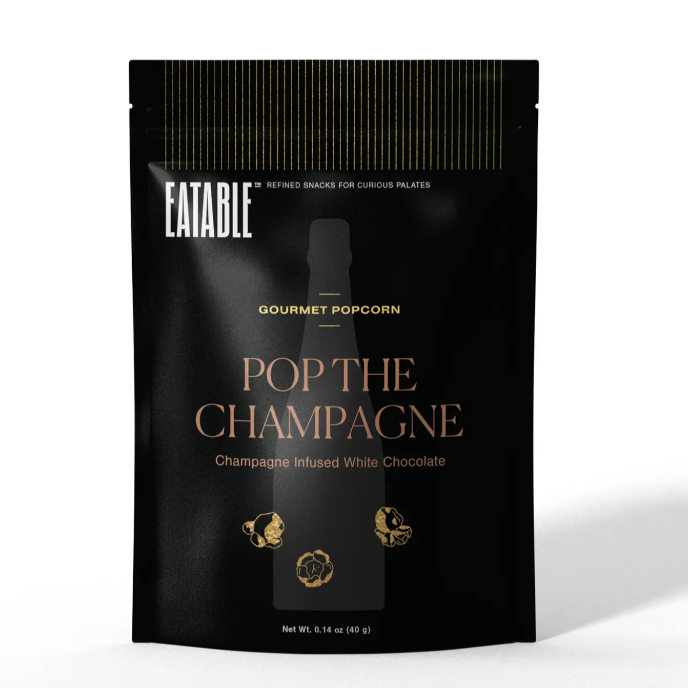 Eatable Pop the Champagne popcorn, featured packaged in a black  resealable foil bag with white gold and rose gold lettering with the silhouette of three popcorns. 