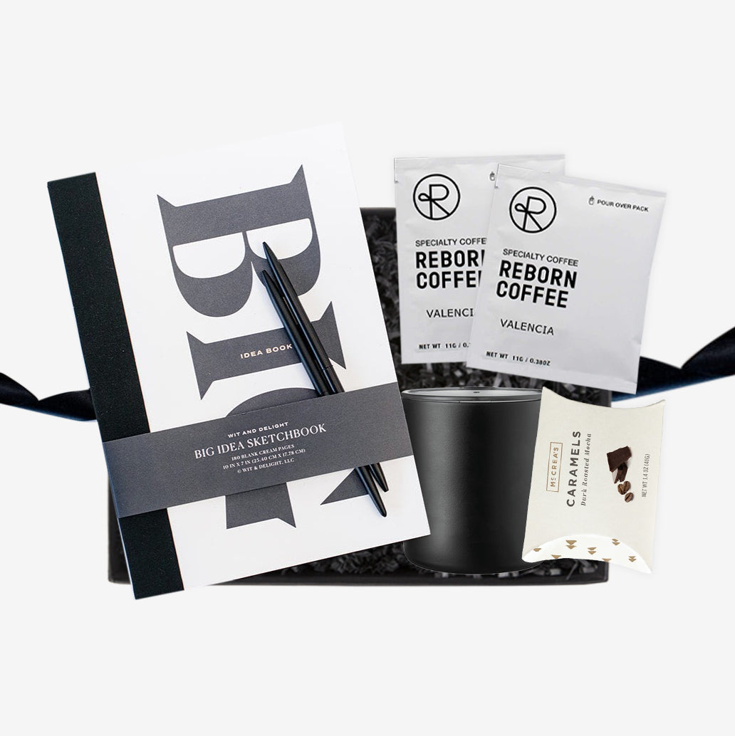 Black box embossed with foxblossom co. filled with black paper shred and tied with black ribbon.