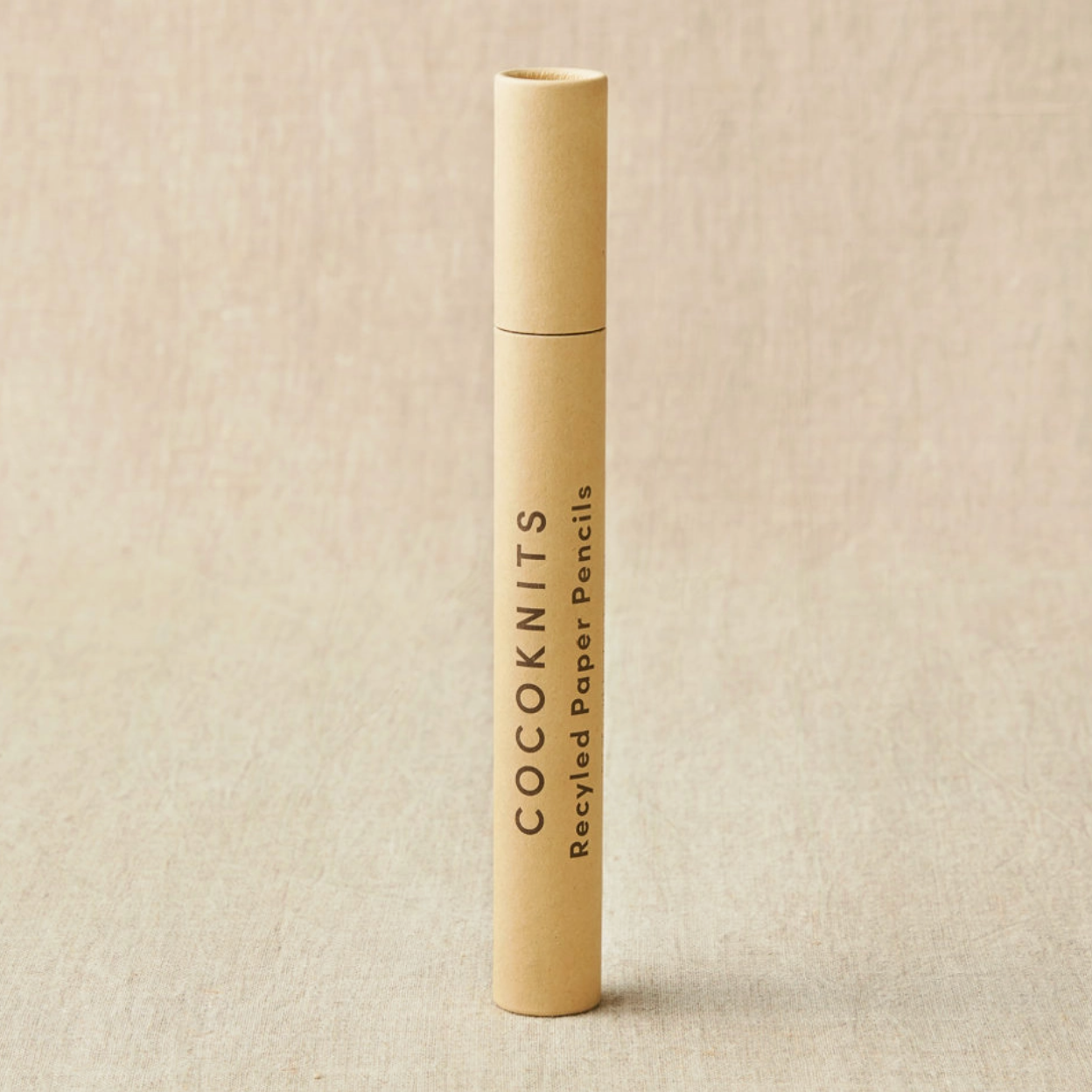 Beige cylindrical container with 'COCKKNITS' branding on a beige background