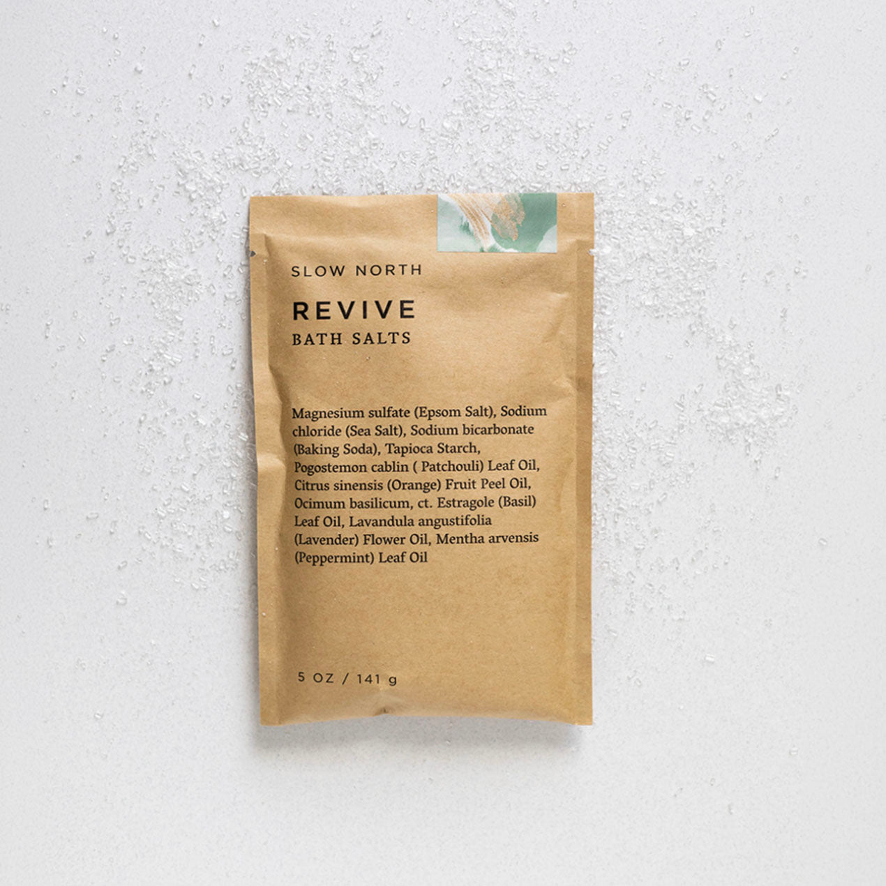 Brown package of Slow North Revive Bath Salts on a textured white background
