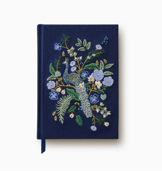 Blue notebook with embroidered peacock.