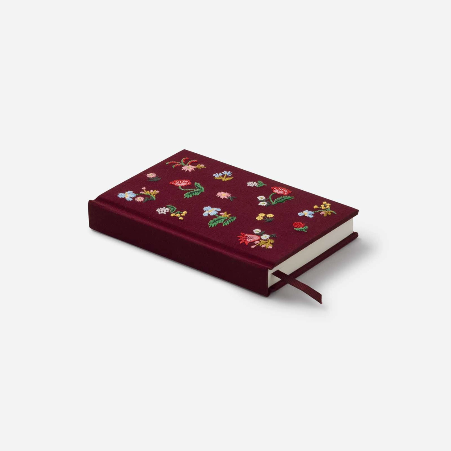 Maroon notebook with floral patterns on a white background
