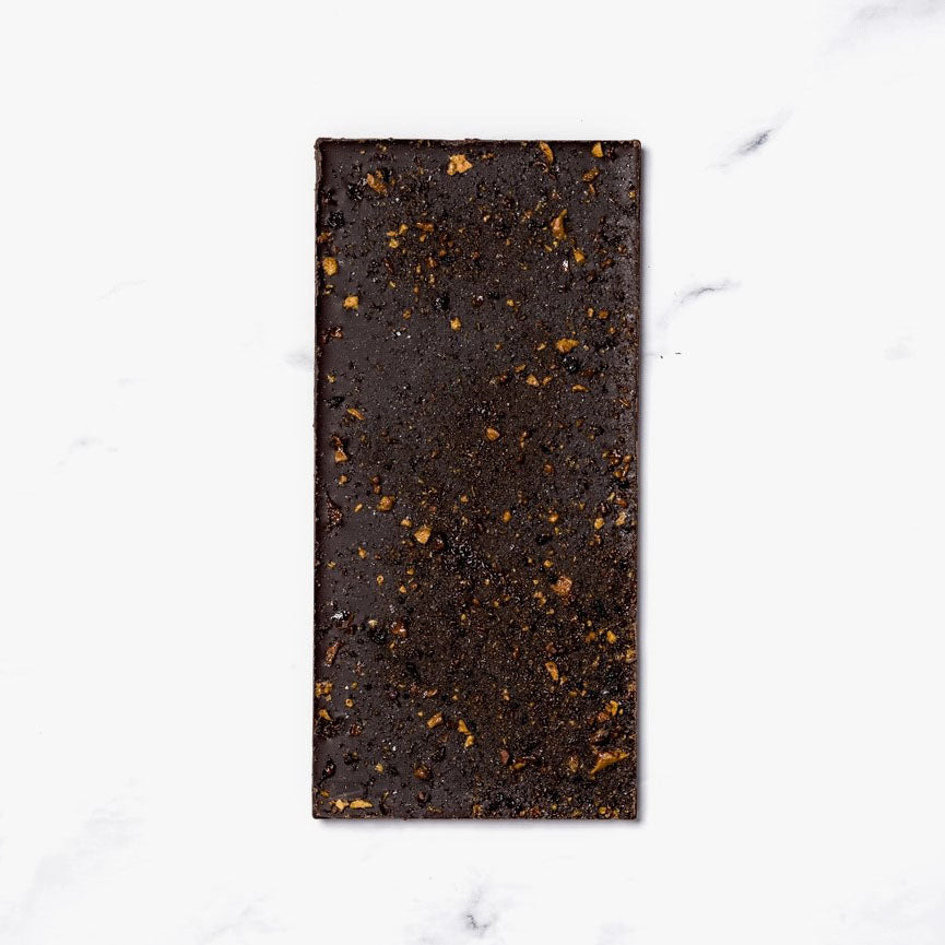 Ritual Honeycomb Toffee Chocolate Bar, image shows the back of the chocolate bark that is dark chocolate with little touches of gold like pieces of honeycomb.