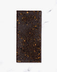 Ritual Honeycomb Toffee Chocolate Bar, image shows the back of the chocolate bark that is dark chocolate with little touches of gold like pieces of honeycomb.