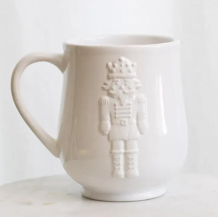 Royal nutcracker embossed coffee mug is featured in its white mug on a white background. 
