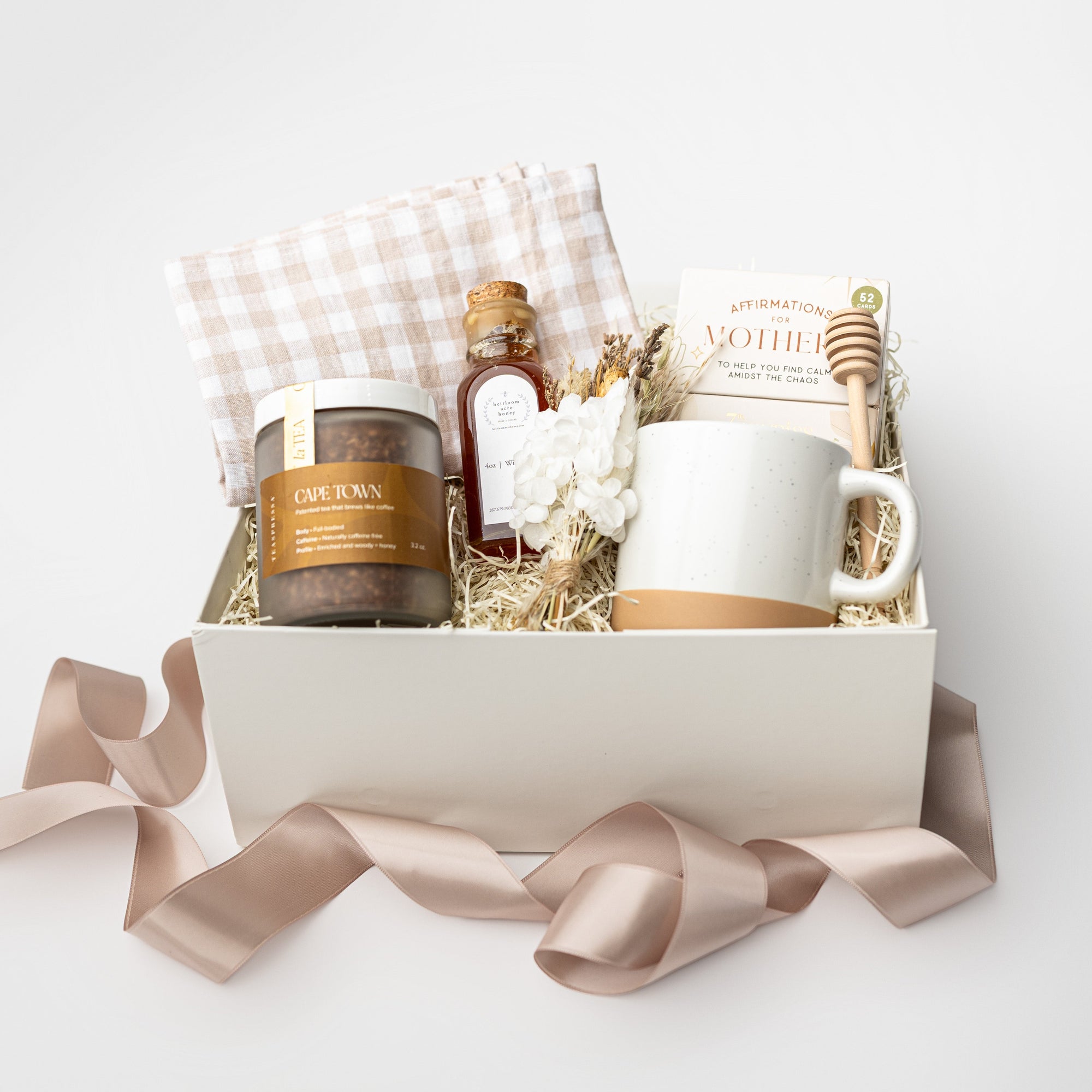 Gift basket with mug, candles, and other items on a white background