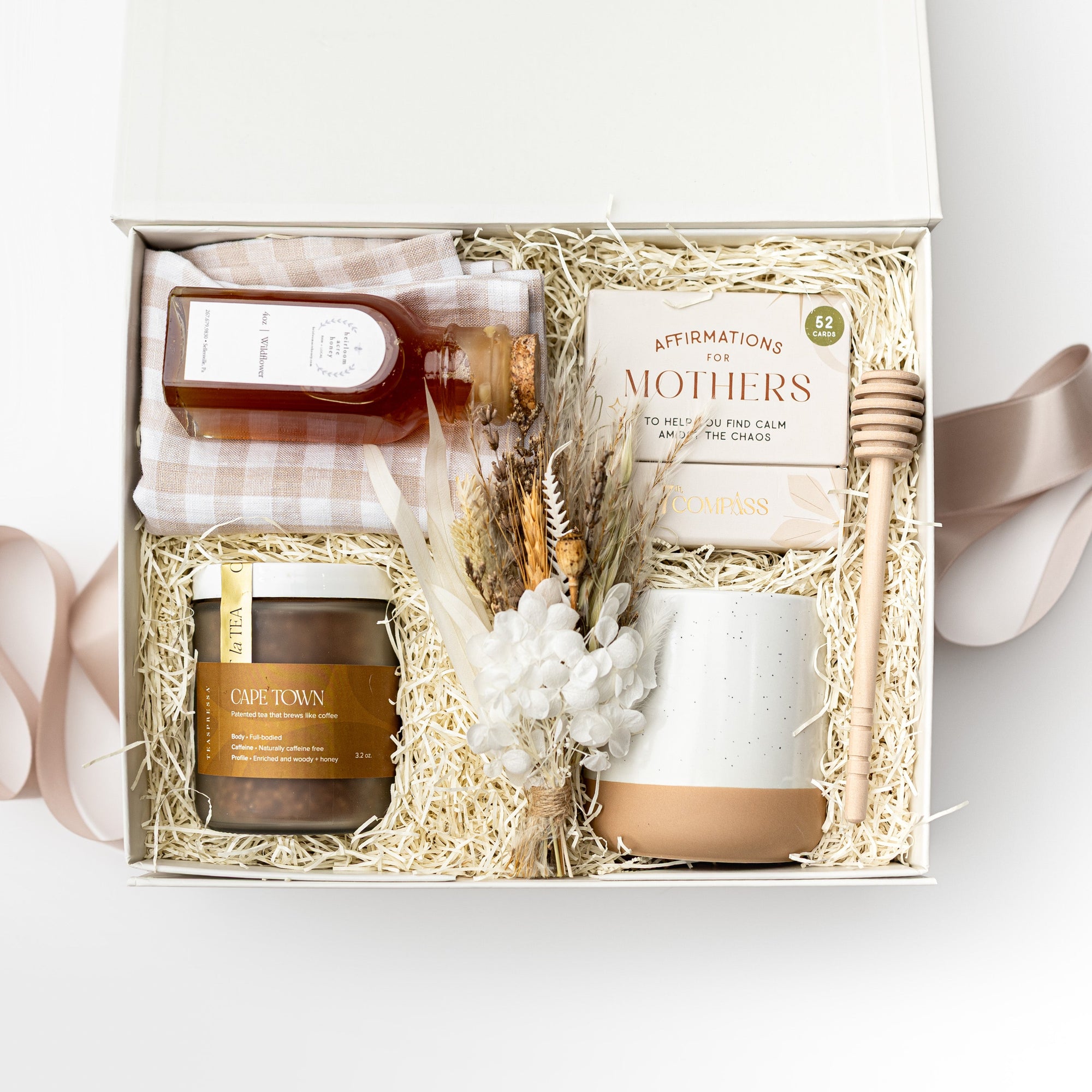 Gift set with candles, honey, and a card in a box on a white background