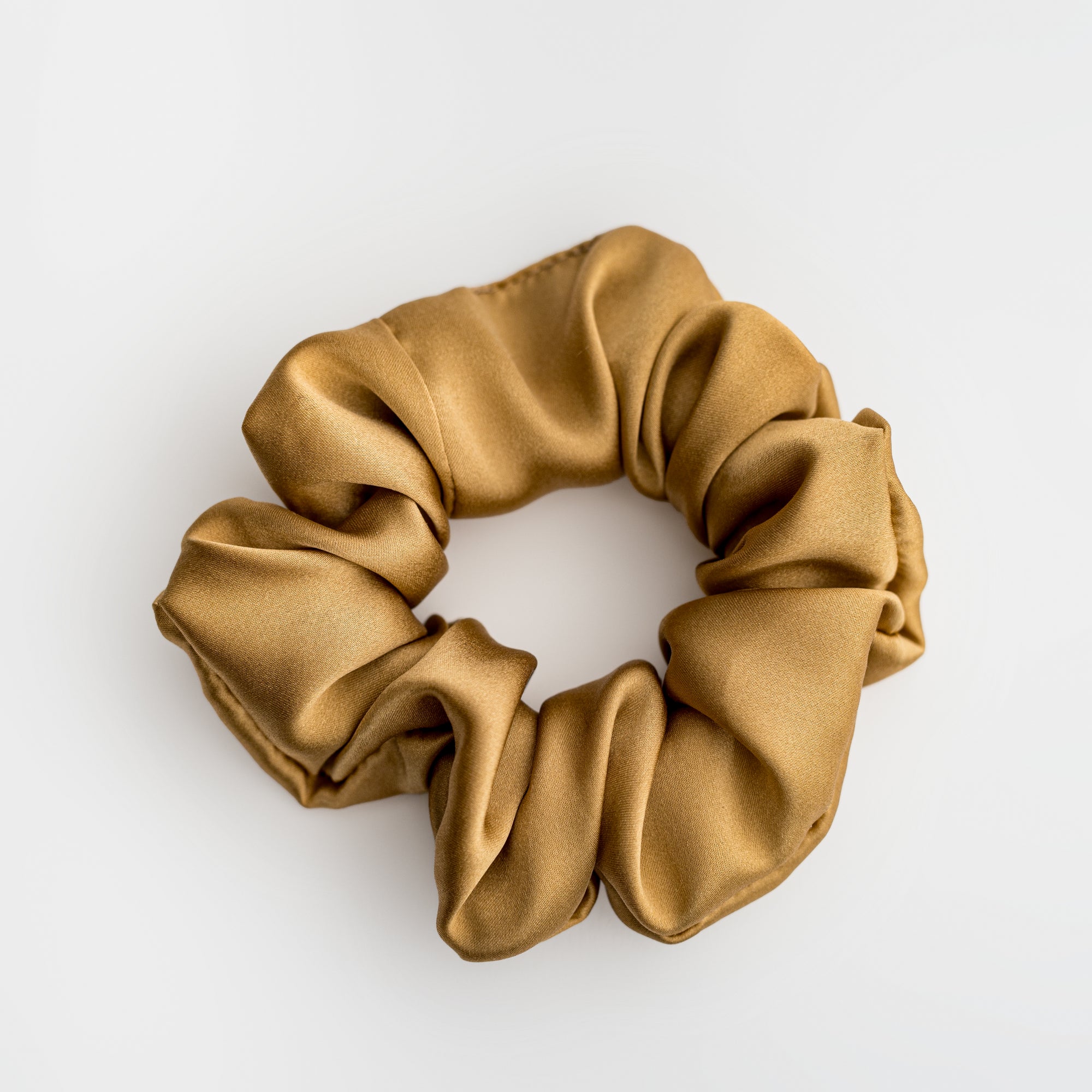 Champagne color scrunchie on a white background. 