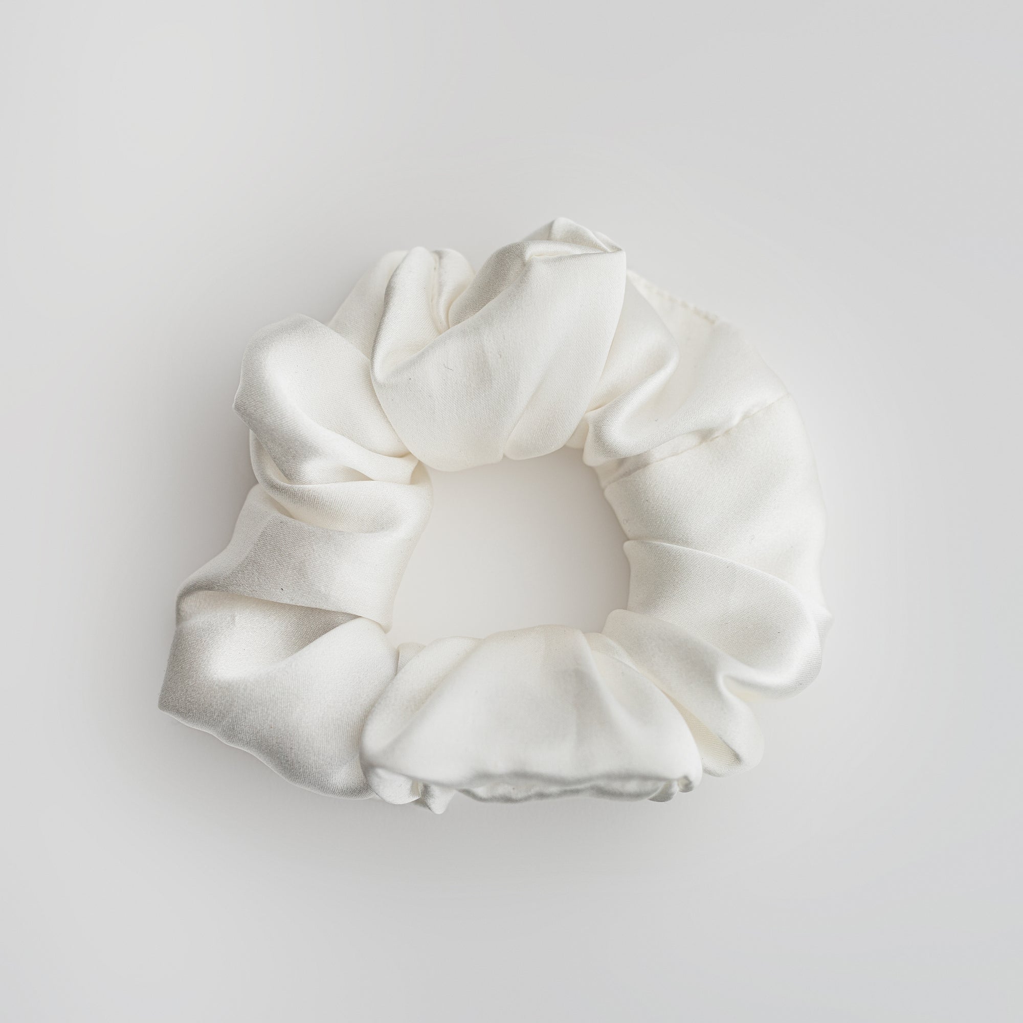 Silk white scrunchie featured on a white background.