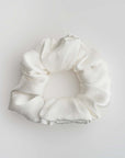 Silk white scrunchie featured on a white background.