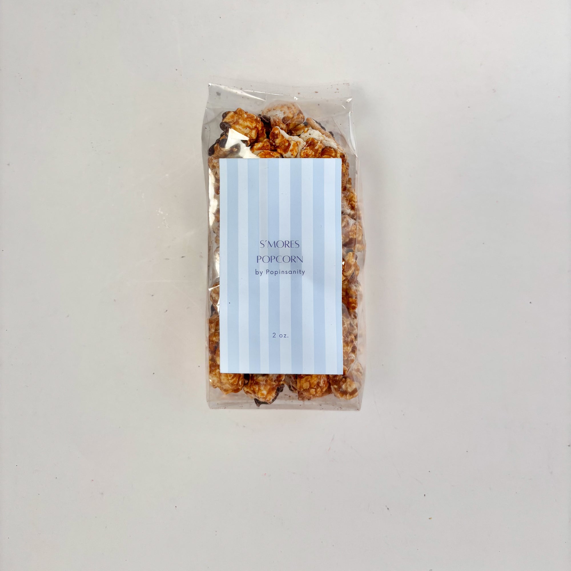 Packaged popcorn with a blue striped label on a light gray background