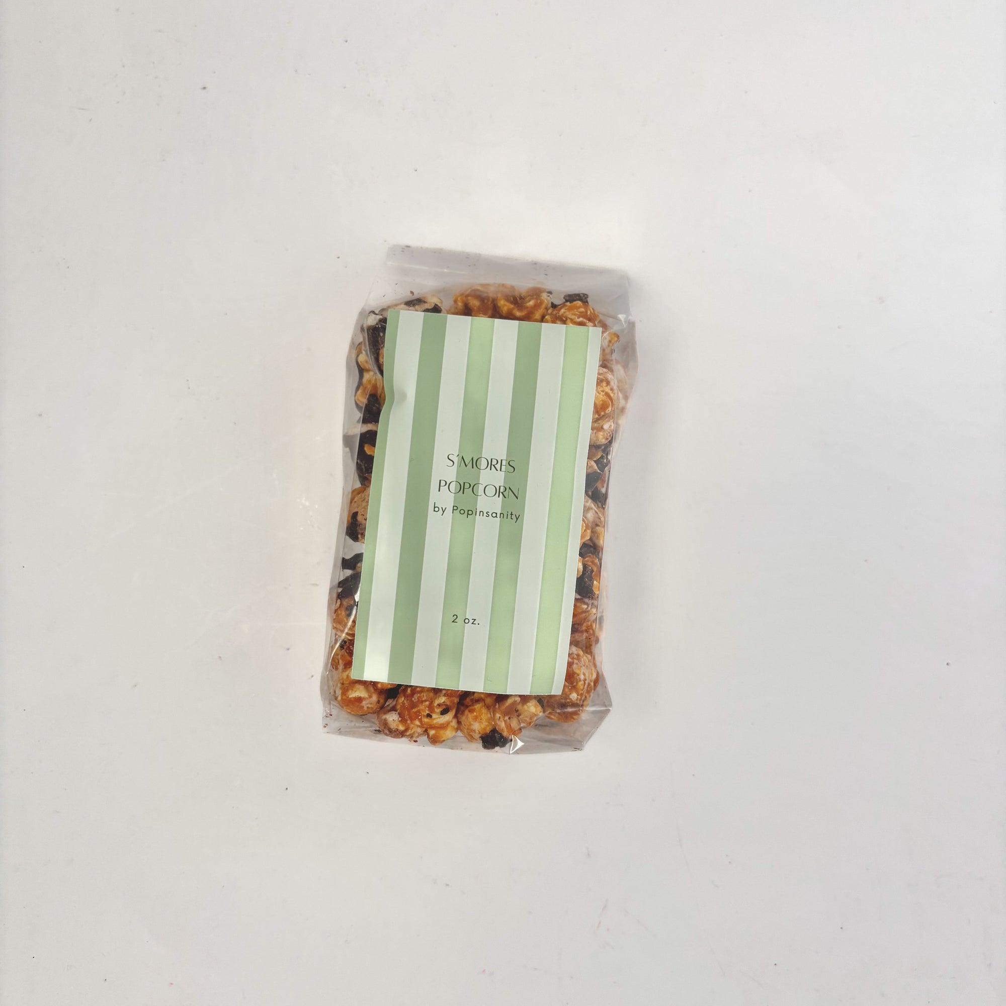 S'mores Popcorn in clear plastic bag with green striped label.