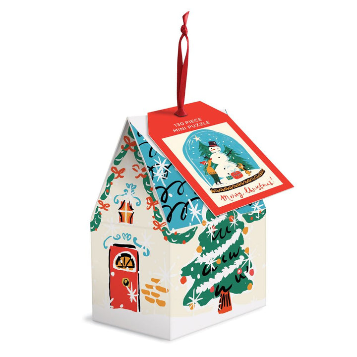Snow globe mini puzzle is featured in its house shape package with Christmas illustrations and tag on a white background. 