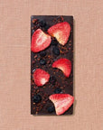 Spring & Mulberry mixed berry chocolate bar is featured which is dark chocolate with mixed berries on top of the chocolate bar in a beige background. 