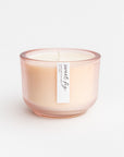 Sweet Fig candle is featured in its pink glass jar container on a white background. 