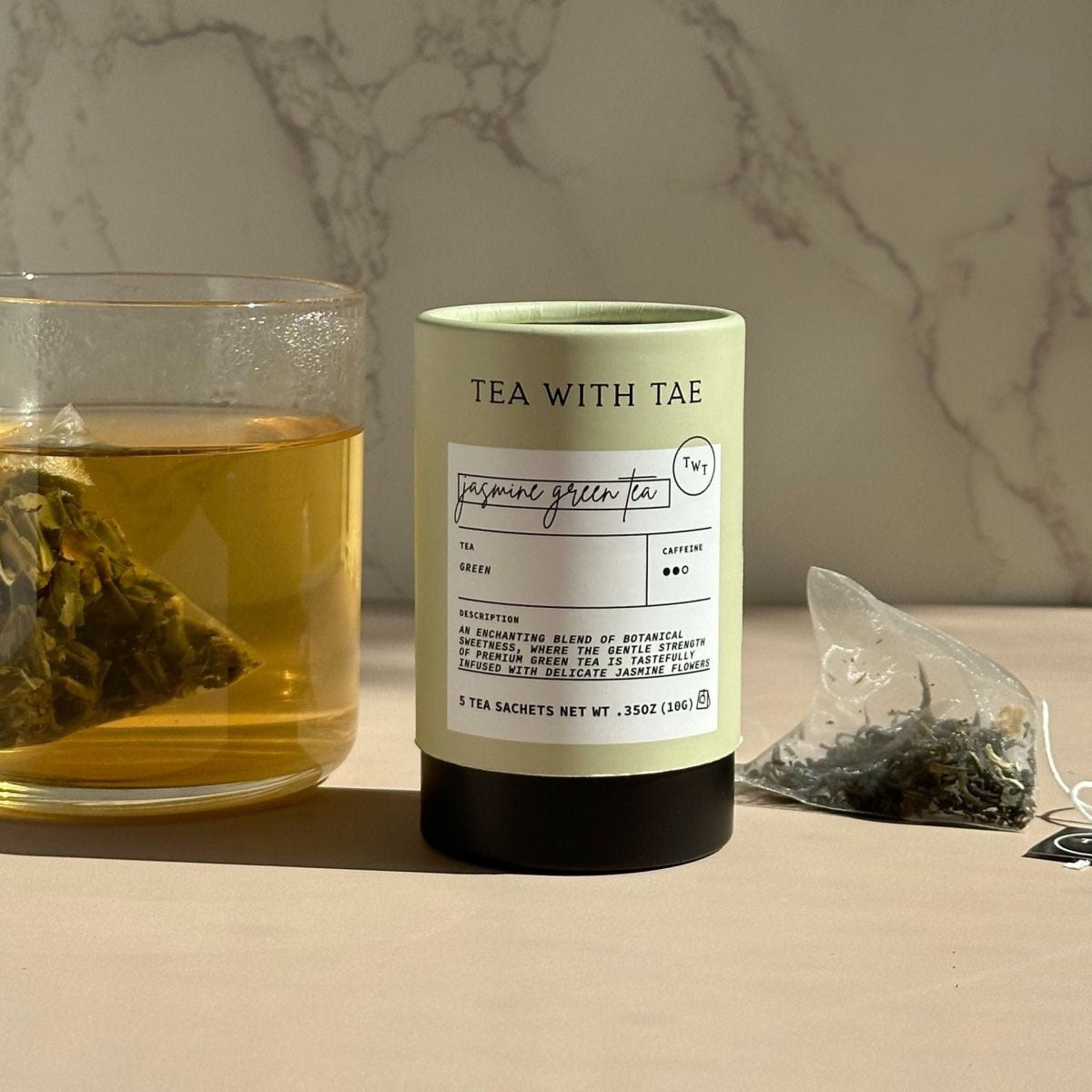 Tea packaging with a glass of tea and tea bag on a marble background