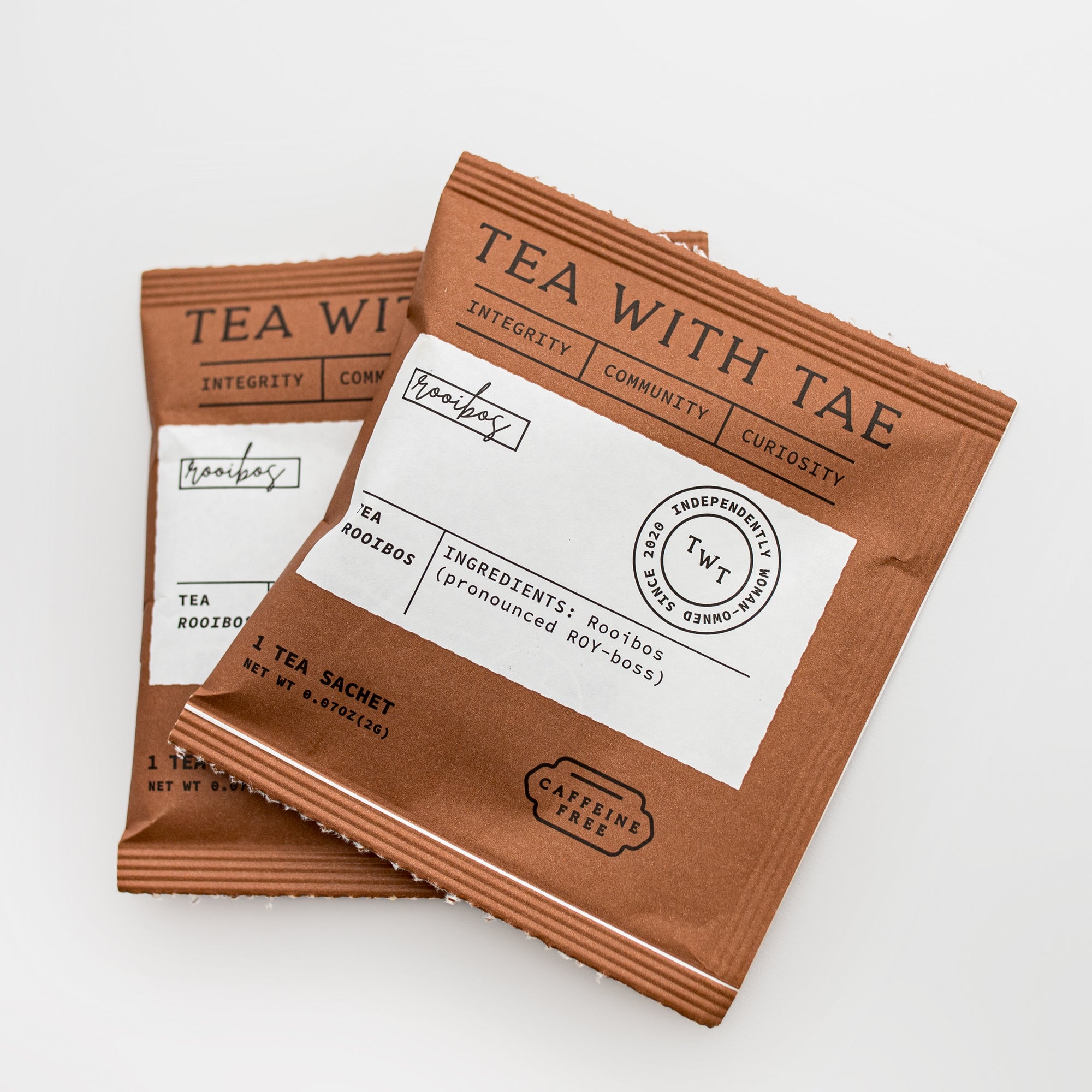 Close-up view of two tea sachets, featuring a brown paper design with a white label and black lettering.