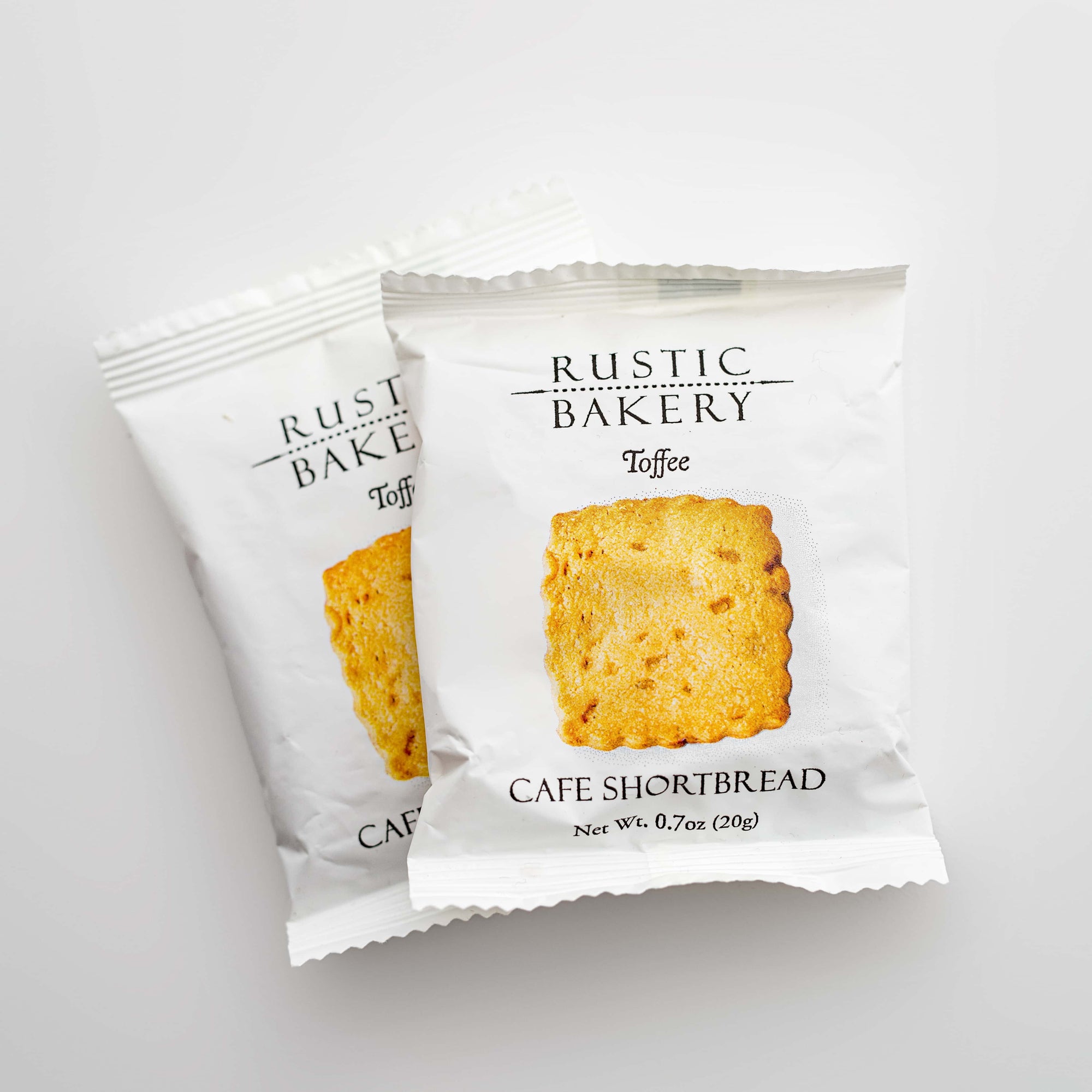 Toffee cafe shortbread pair featured in their square-shaped package white with black lettering and the image of the shortbread on a white background. 