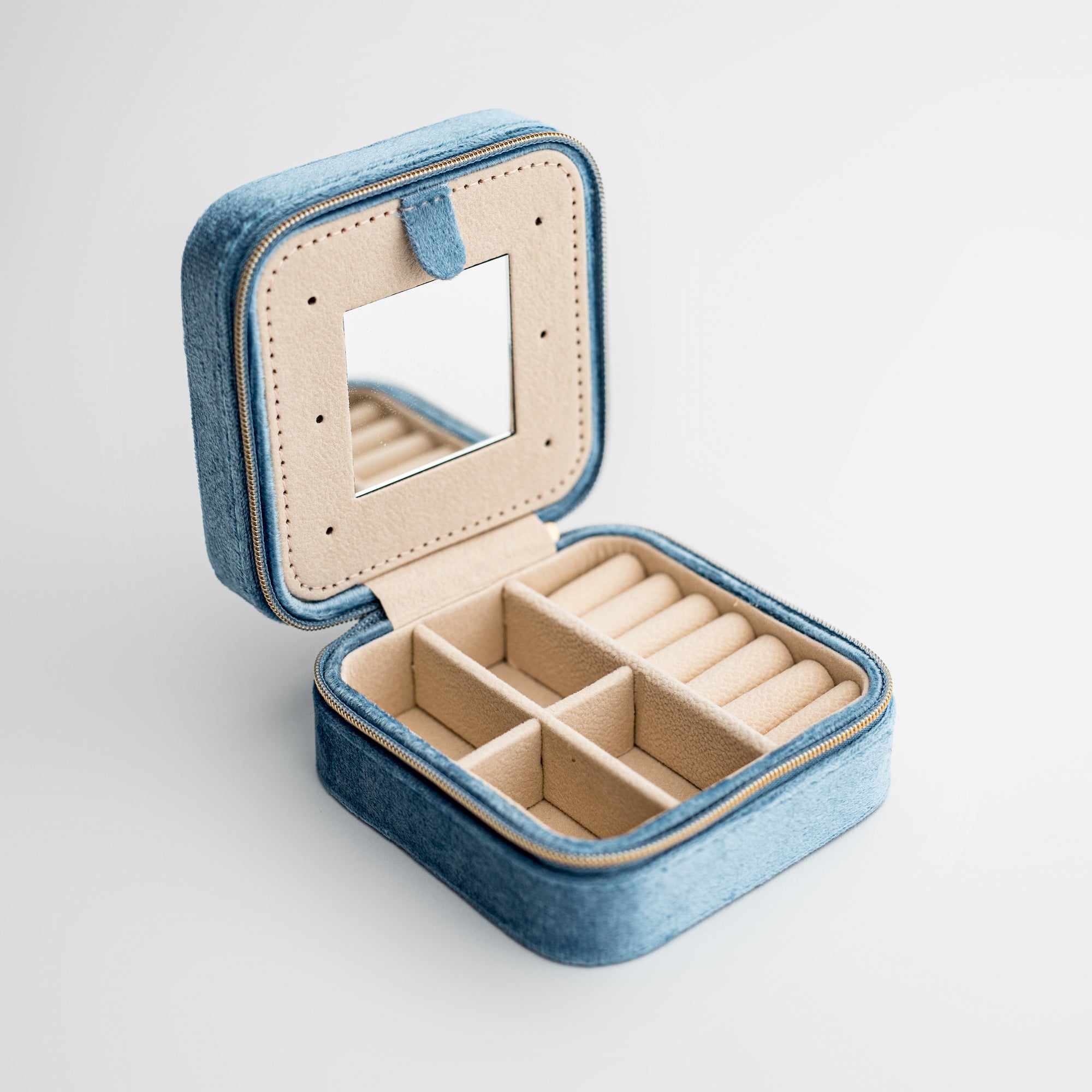 Velvet jewelry box in dusty blue, dusty blue box with cream divisions inside and a mirror. 