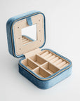 Velvet jewelry box in dusty blue, dusty blue box with cream divisions inside and a mirror. 
