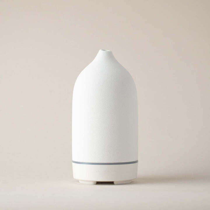 White stone diffuser in its cylindrical shape featured in a beige background.