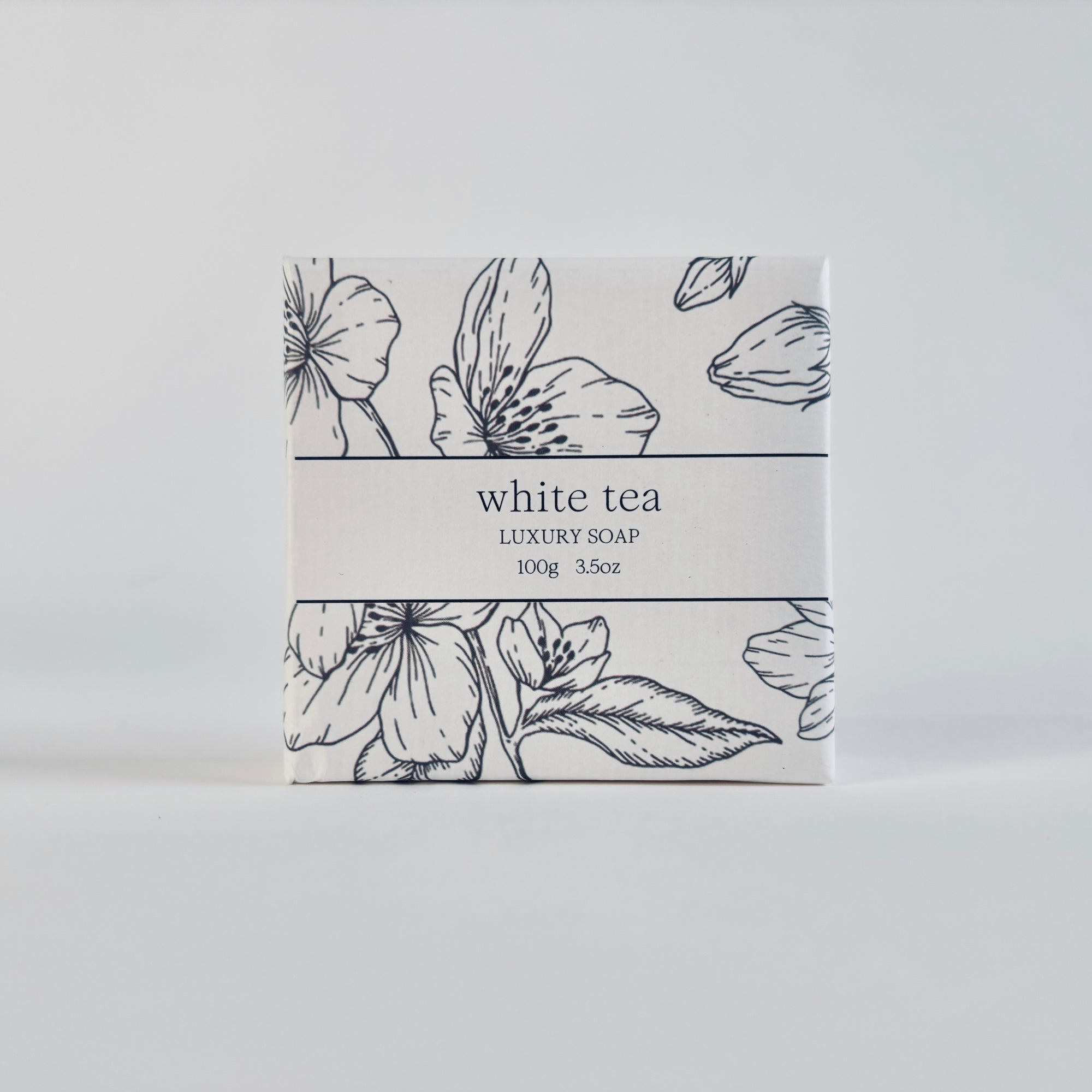 White tea luxury soap is featured in its square-shaped package with flower illustration in black and black lettering with the information. 