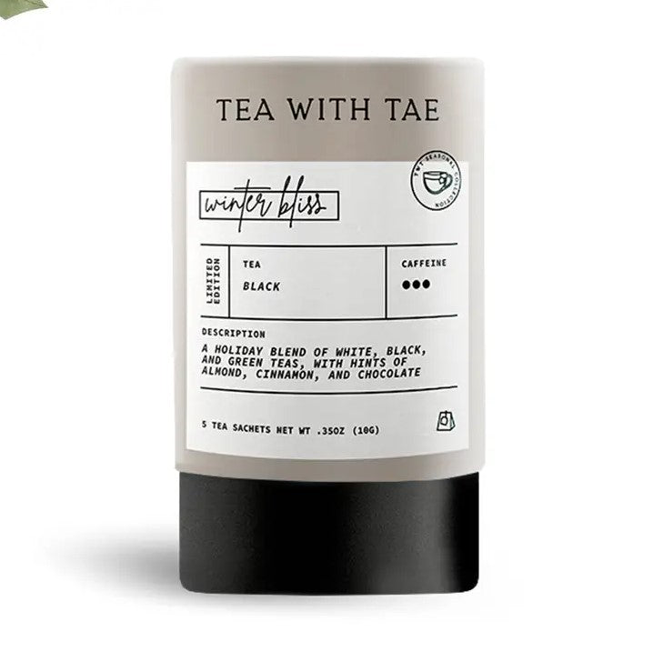 Tea with tae winter bliss tea is featured in its cylindrical shape container grey, black bottom and white label with black lettering.