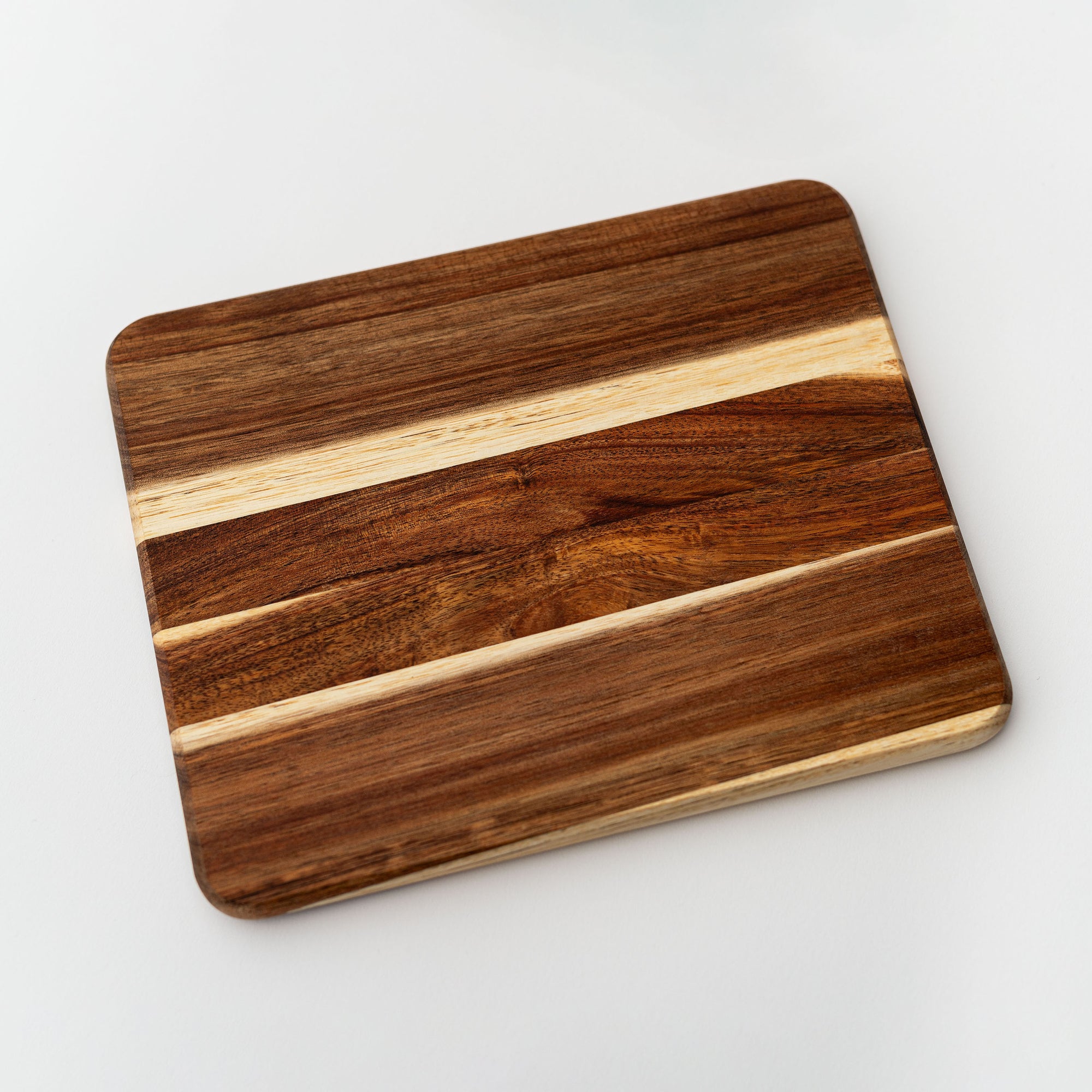 Wooden cutting or serving board brown wooden colored is featured on a white background. 