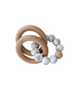 Wodden silicone marble teether with two wodden rings and one blue marble one on a white background. 