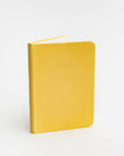 Yellow pocket softcover notebook featured on a white background.  With Notes printed in front of it. 