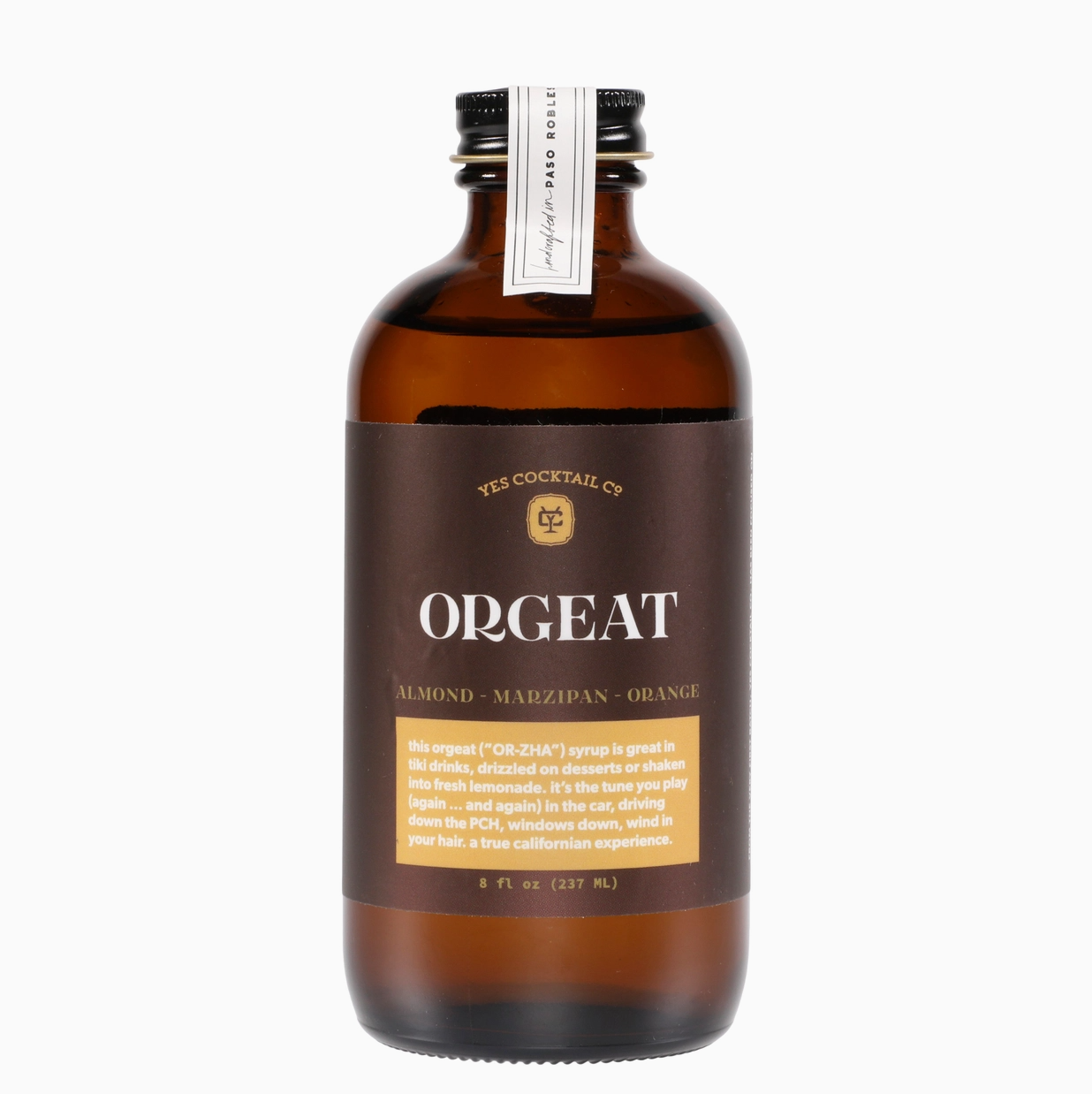 Yes Cocktail Orgeat Mix shown in an amber-colored jar with a black lid, featuring a brown label with a yellow company symbol and an orange square containing white lettering, displayed on a white background.