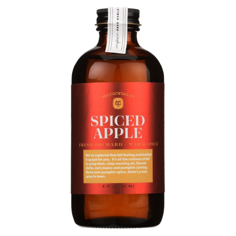 Yes cocktails, spiced apple mixer featured, in its amber glass jar  with black lid in red label with white and yellow lettering and details on a white background.