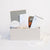 8" spiral top bound grey Appointed Notebook, teakwood & cardamom 8 oz white candle, appointed task adhesives, Modern Sprout Prickly Pear Cactus grow kit in terracotta pot, 16 oz white Miir Tumbler, and set of two gold pens in a light grey gift box.