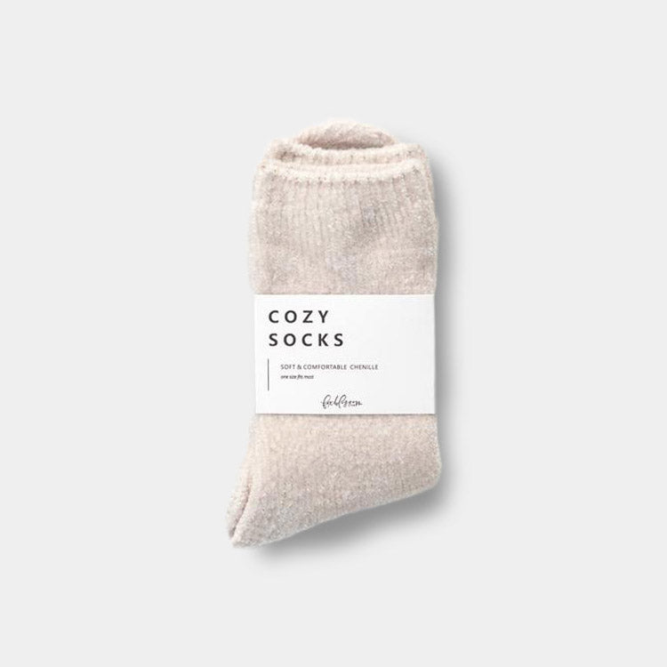 Nude pair of chenille socks. Has a white band around the center that reads "Cozy Socks"