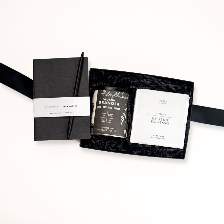 Banner Road midnight snack granola, Eastside instant Espresso packets, a black pen, and an appointed mini linen all in a black gifting box.