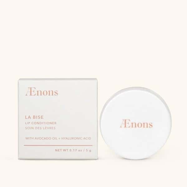 Round, white La Bise Lip Conditioner shown outside of packaging.