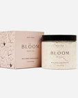 White, textured grapefruit scrub in a clear glass jar, black twist off top, black text. Comes in a light pink box, black text. 