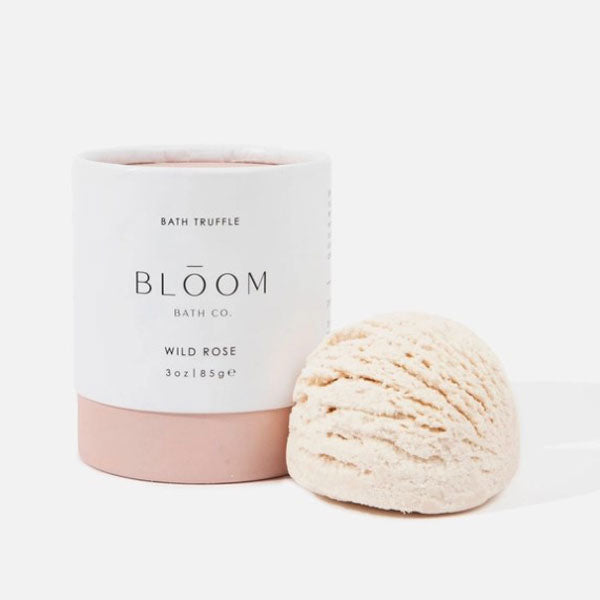 White and pink colored cylinder container, black text, inside bath truffle a cream frozen yogurt like texture.