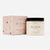 White, textured grapefruit scrub in a clear glass jar, black twist off top, black text. Comes in a light pink box, black text. 