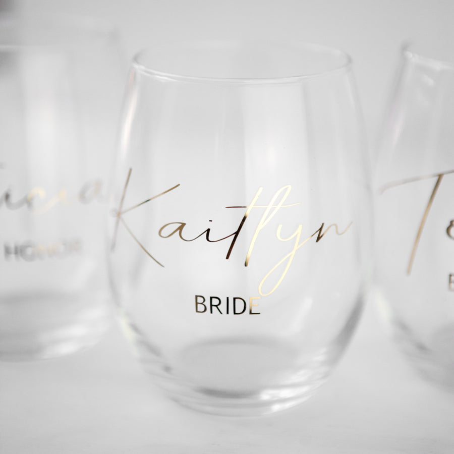 Personalized bridal party wine glasses with names and titles like Bride, Kaitlyn, in script.