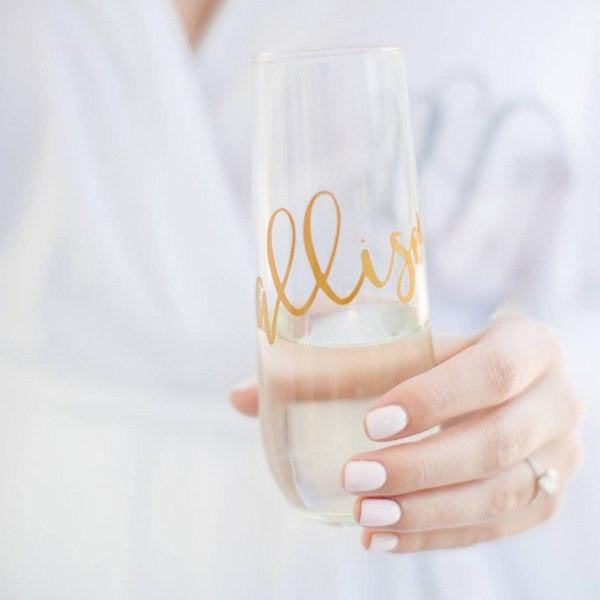 Personalized Champagne Flute, stemless, a bride holding one with gold lettering with the name Allison. 
