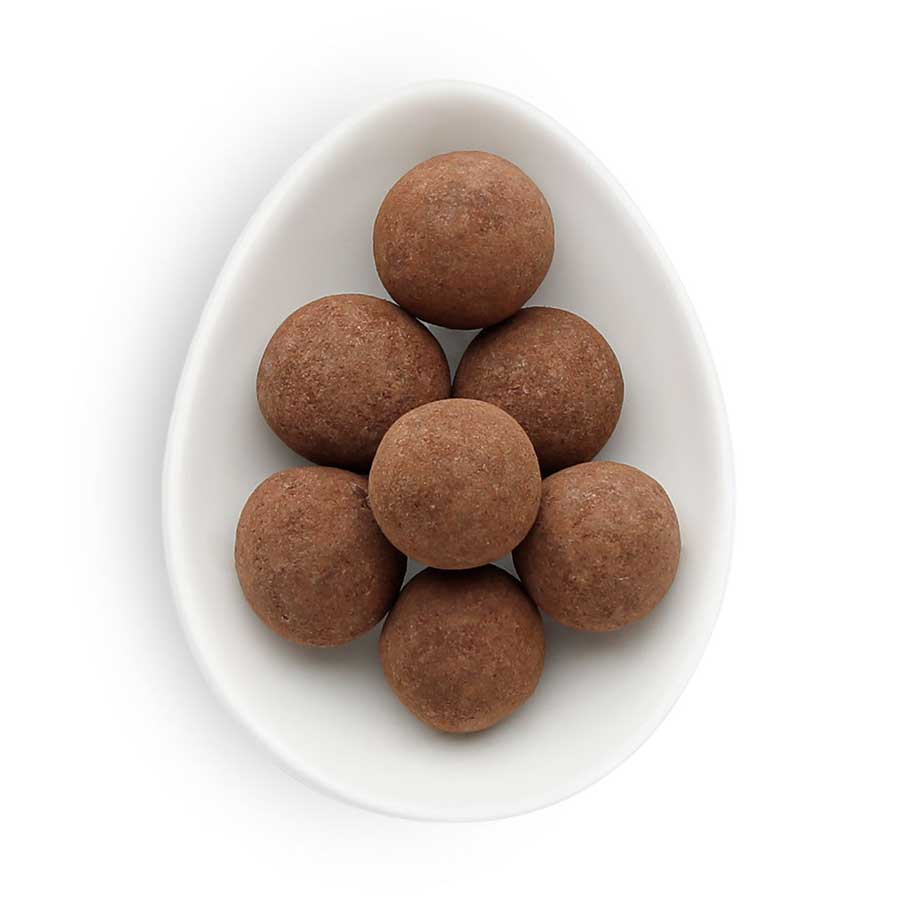 Powdered brown balls in a small white ovular dish.