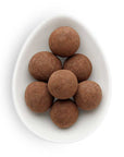 Powdered brown balls in a small white ovular dish.