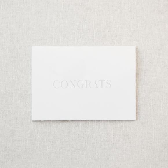 White greeting card with embossed "congrats"