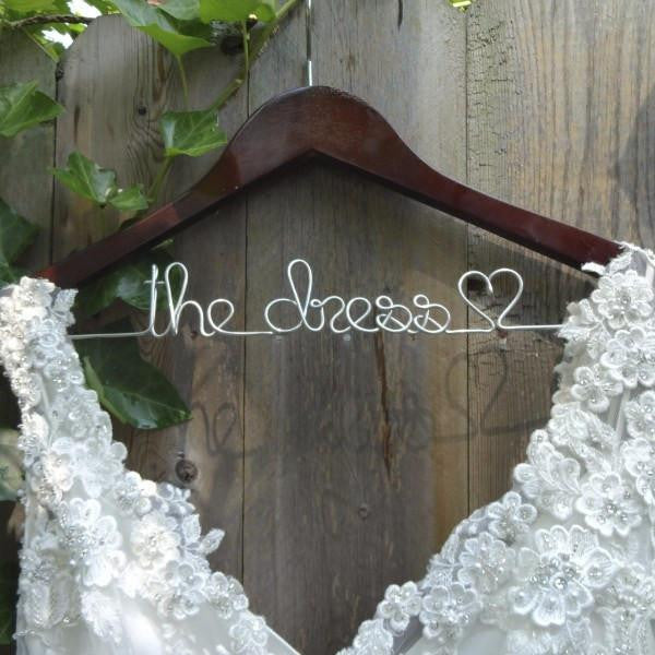Personalized white hanger with gold hook. Gold wire base shaped into personalized name.