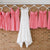 Wedding dress and bridesmaid dresses hung on custom white hangers with base wires shaped into names